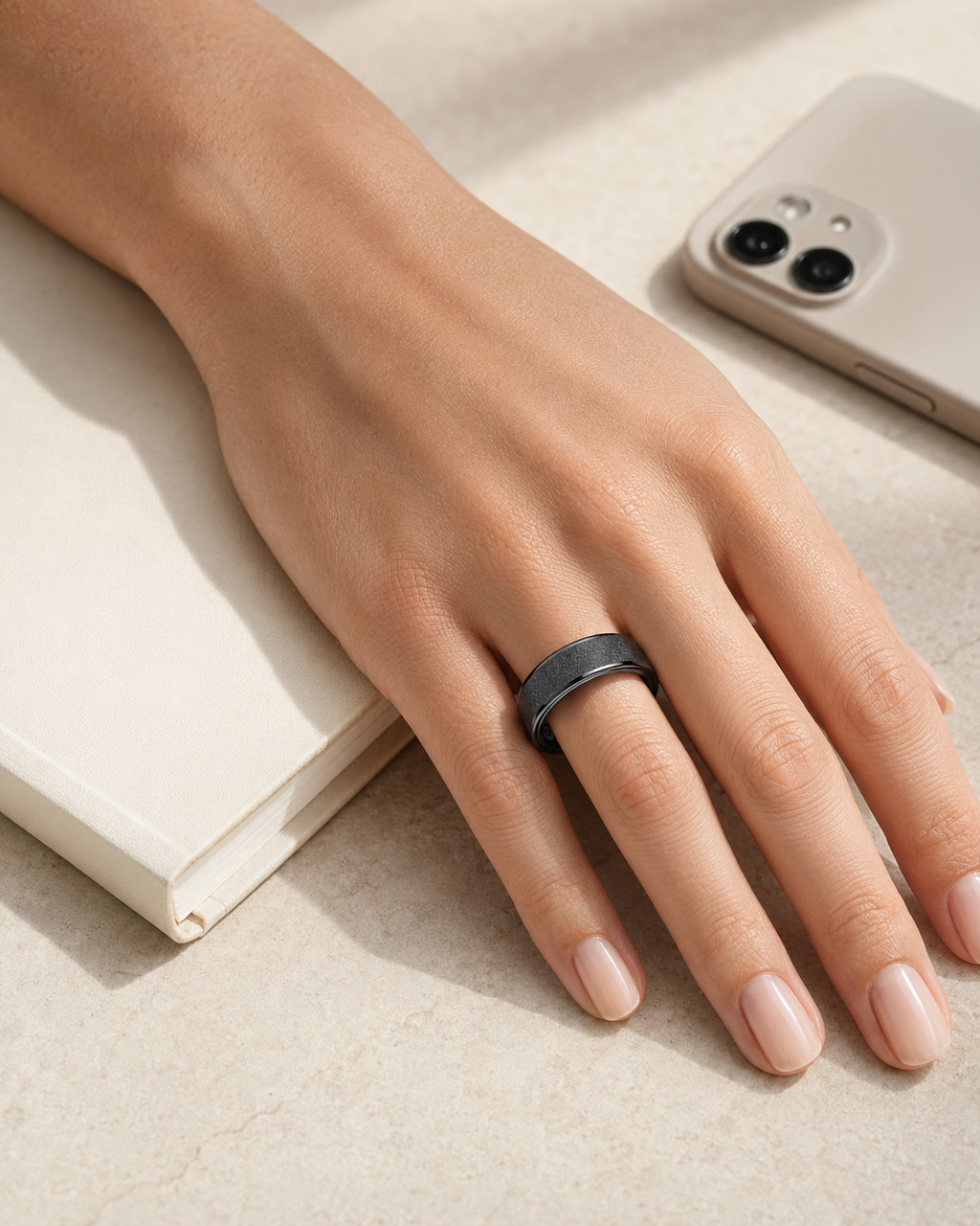 The Insight Ring worn beside a journal and phone